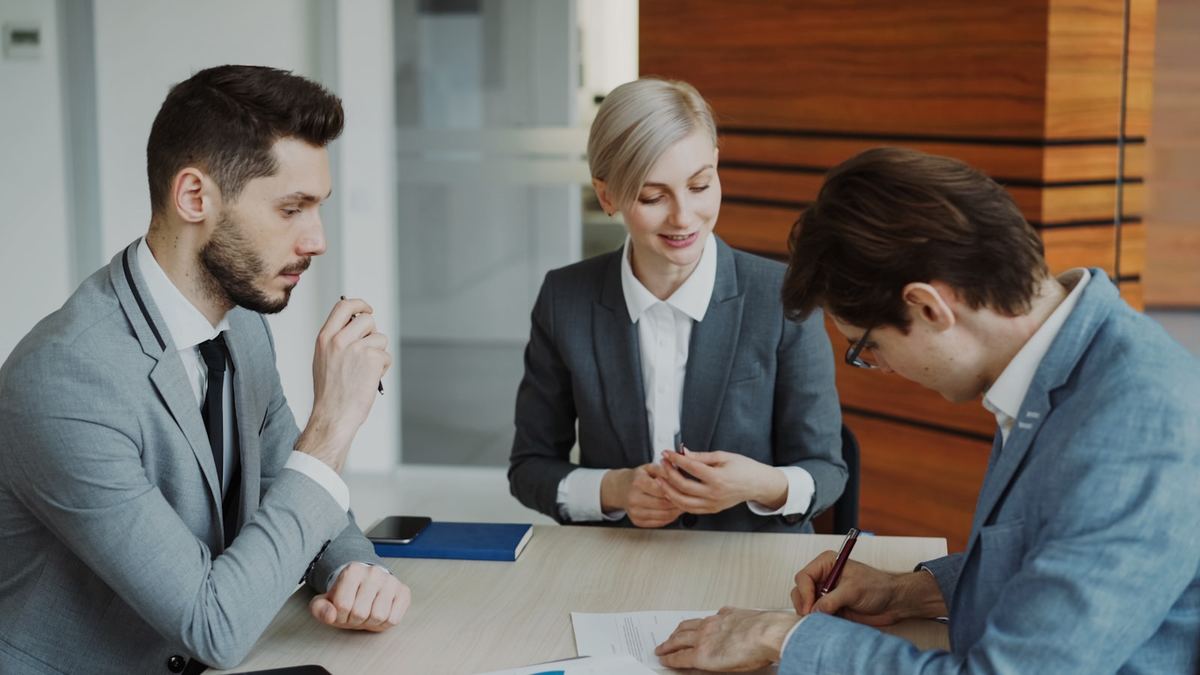 Equipo de negocios revisando y firmando un contrato de servicios de marketing digital